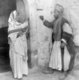 Palestine: A Palestinian man and woman posing in a doorway, c. 1900