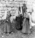 Palestine: Young Palestinian girls dancing while an older woman claps time and a man watches over the scene armed with a rifle. Bethlehem, ca. 1900